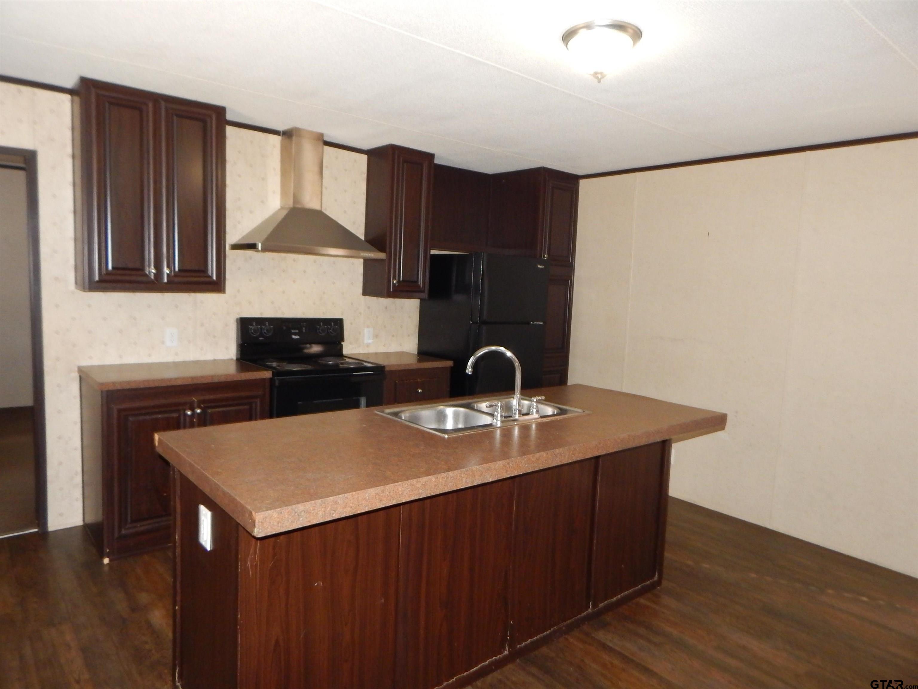 958 Boles Road Gilmer, TX 75645 - Photo 6 of 29 a kitchen with stainless steel appliances a sink and a refrigerator
