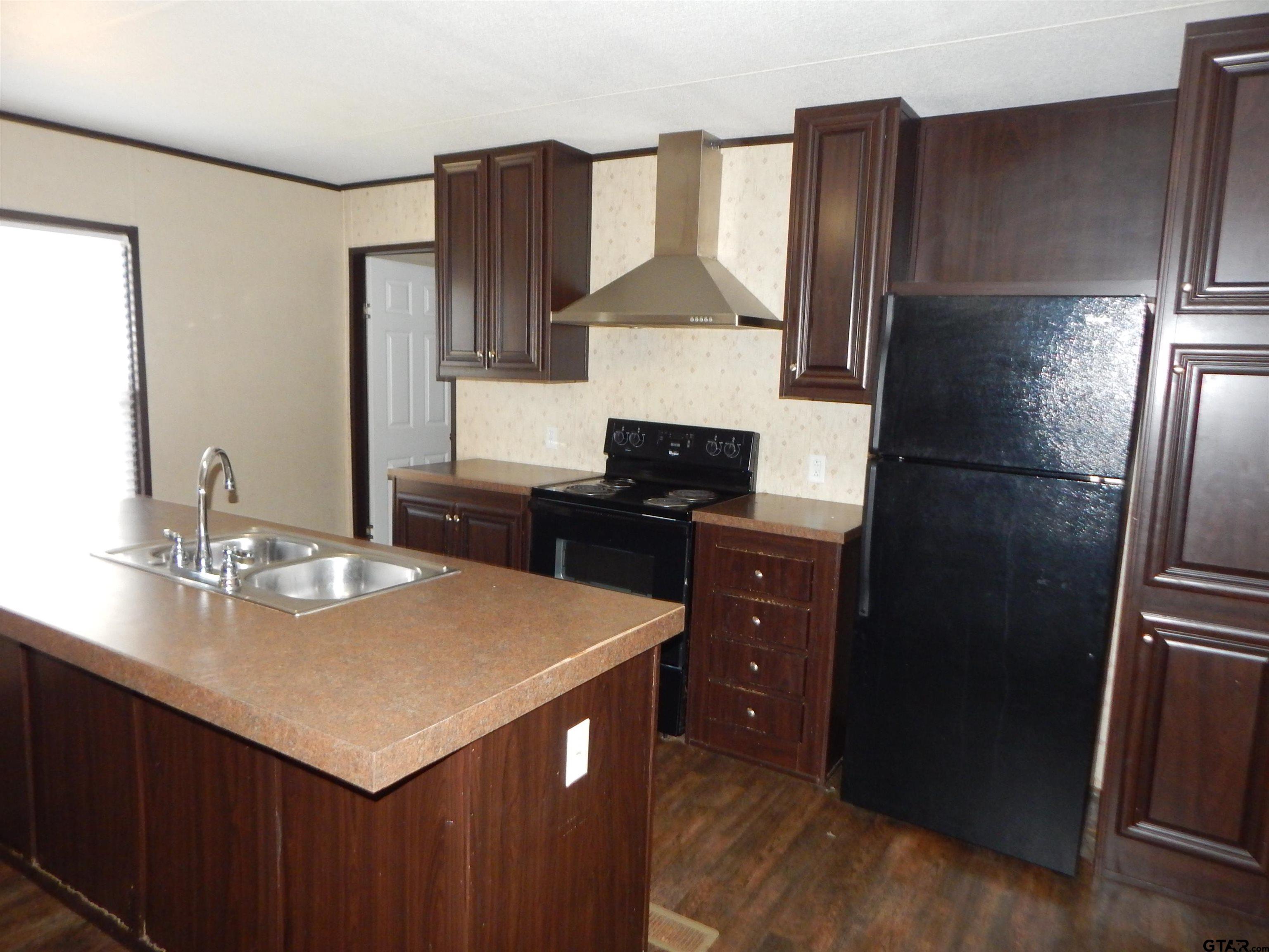 958 Boles Road Gilmer, TX 75645 - Photo 7 of 29 a kitchen with a refrigerator and a sink