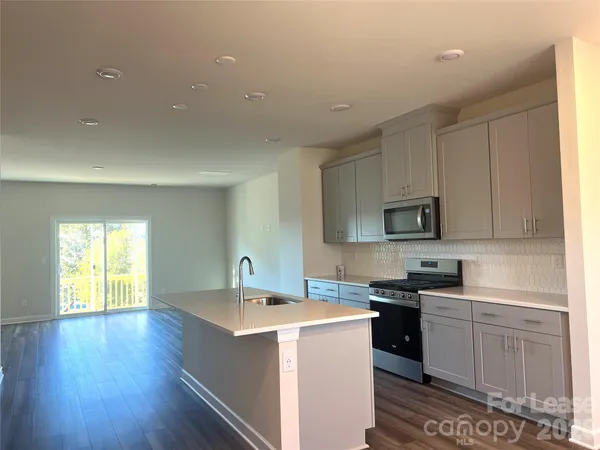 a kitchen with sink cabinets and wooden floor