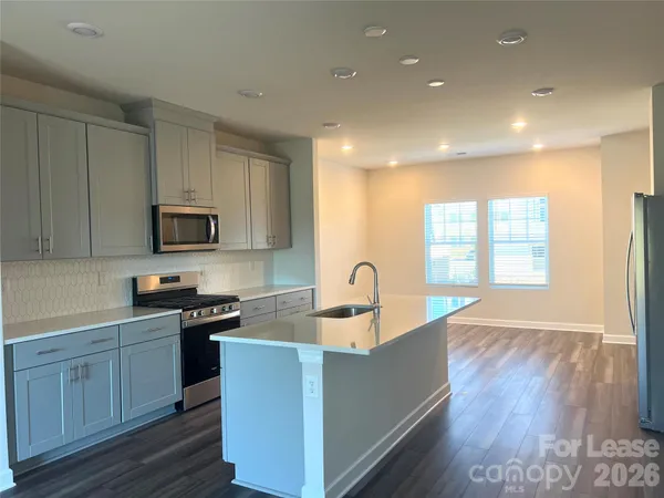a kitchen with kitchen island granite countertop a sink and wooden cabinets