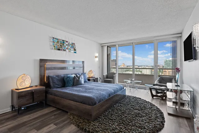 a living room with furniture a rug and a floor to ceiling window