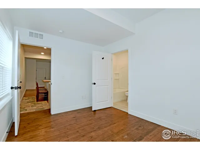 a view of an empty room with wooden floor