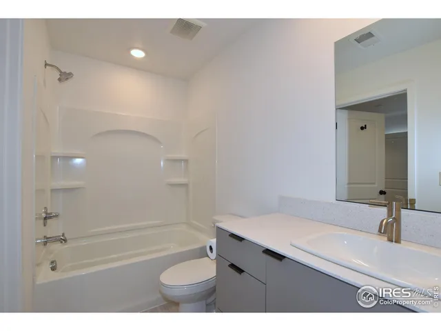 a bathroom with a granite countertop sink a toilet and shower