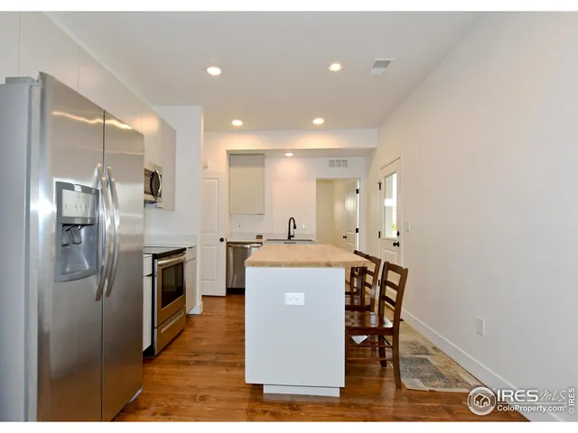 a kitchen with stainless steel appliances granite countertop a refrigerator and a stove