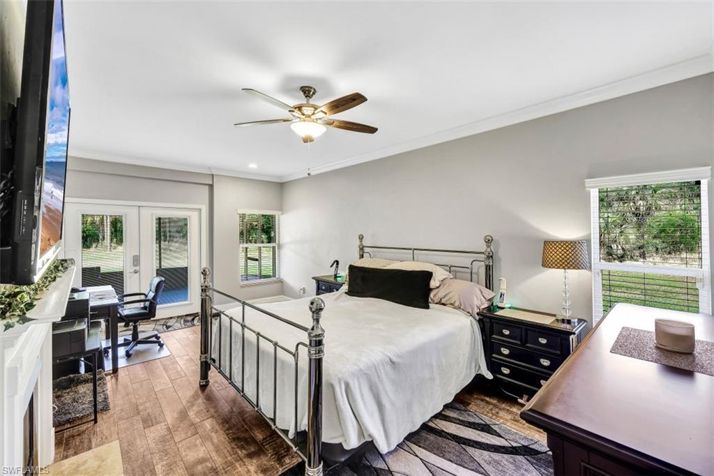 2875 Garland Road Naples, FL 34117 - Photo 12 of 34 a bedroom with a bed a large window with table and chairs