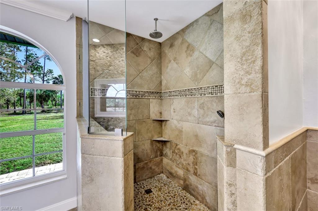 2875 Garland Road Naples, FL 34117 - Photo 15 of 34 a bathroom with a glass shower door