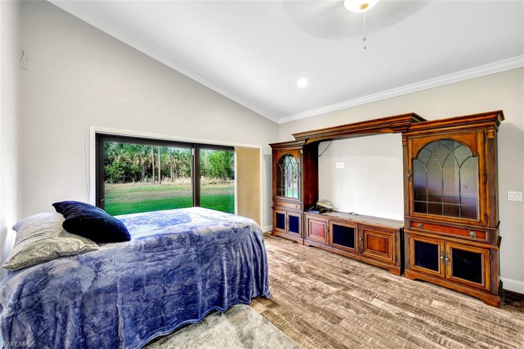 2875 Garland Road Naples, FL 34117 - Photo 18 of 34 a living room with a bed furniture a flat tv screen and a fireplace