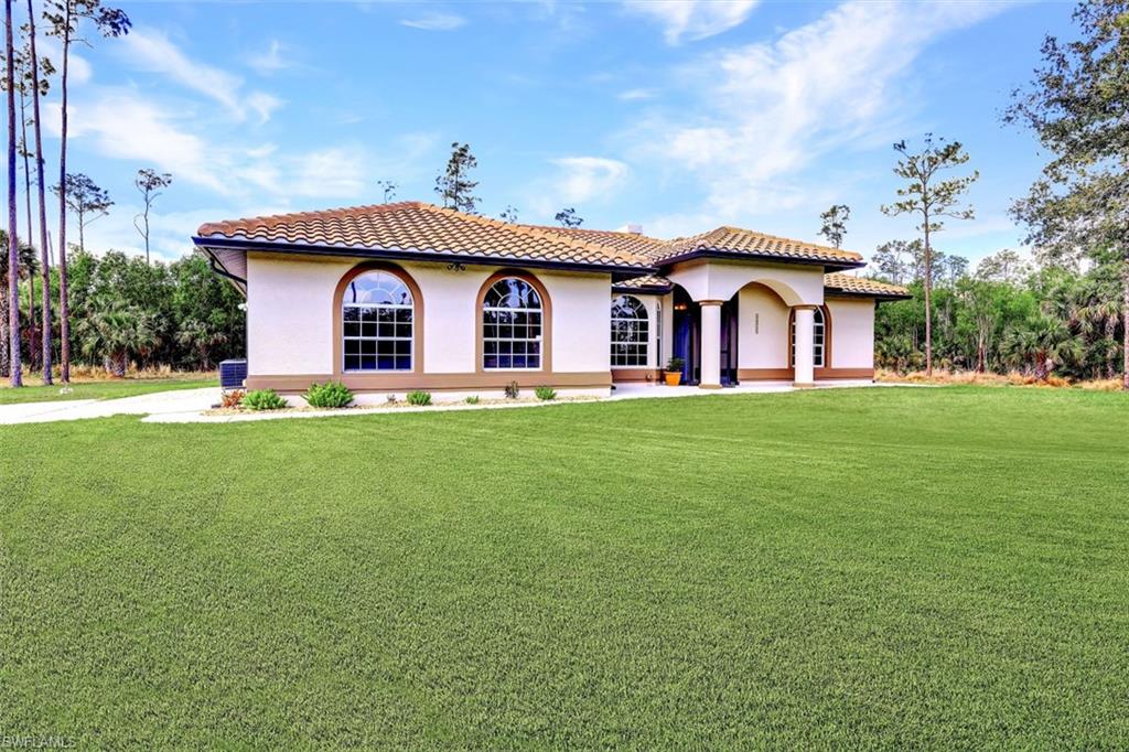 2875 Garland Road Naples, FL 34117 - Photo 2 of 34 a front view of a house with a yard