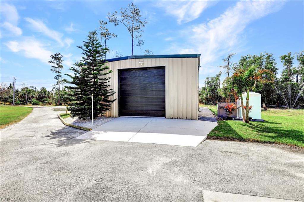2875 Garland Road Naples, FL 34117 - Photo 25 of 34 a front view of a house with a yard and garage