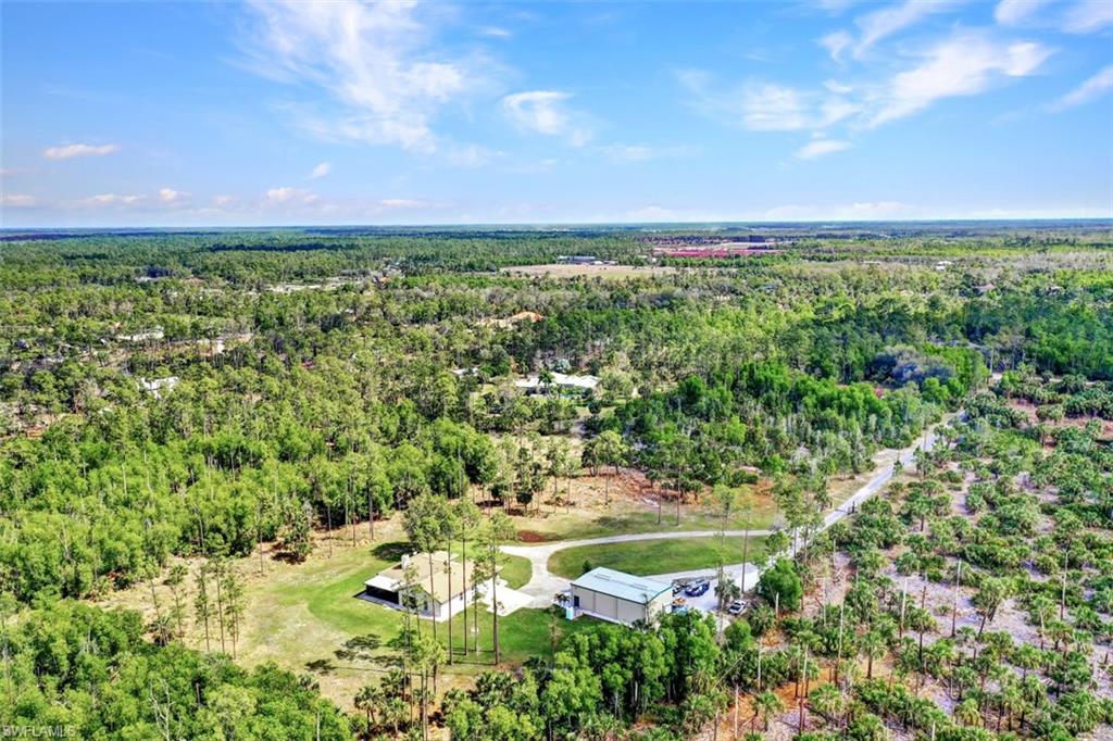 2875 Garland Road Naples, FL 34117 - Photo 29 of 34 a view of a yard with plants and a bench