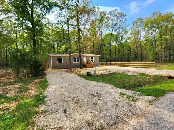 a view of a house with backyard and trees
