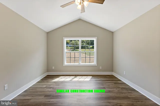 an empty room with wooden floor and window