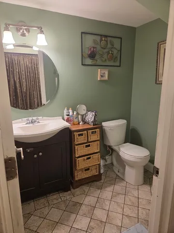 a bathroom with a sink a toilet and a mirror