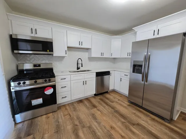 a kitchen with stainless steel appliances granite countertop a refrigerator stove and sink
