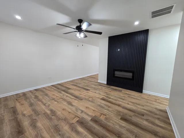 a view of an empty room with a ceiling fan