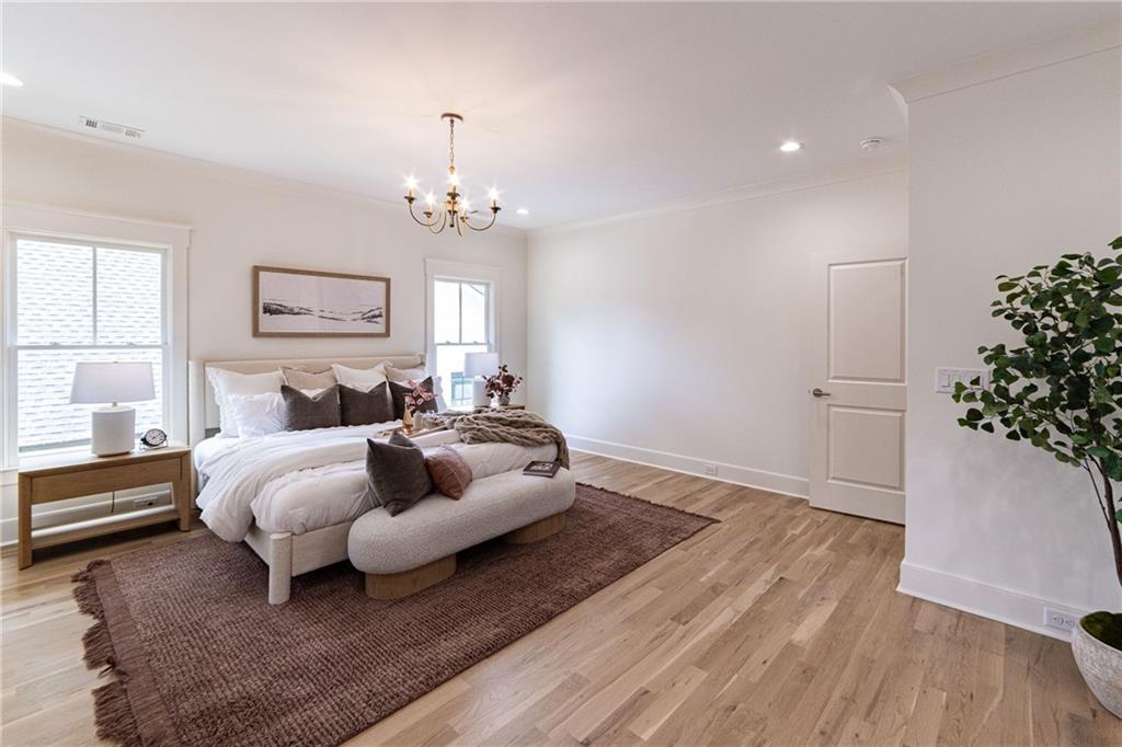 585 Sherwood Road Northeast Atlanta, GA 30324 - Photo 36 of 104 a spacious bedroom with a bed and a potted plant