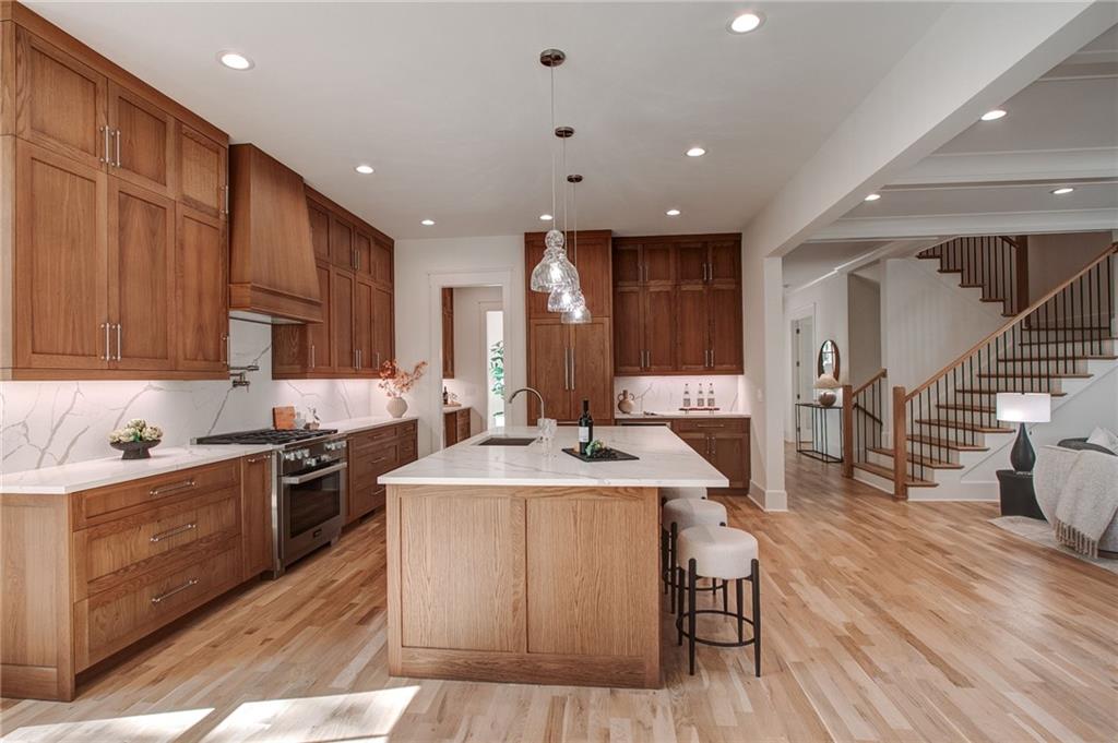 585 Sherwood Road Northeast Atlanta, GA 30324 - Photo 8 of 104 a large kitchen with stainless steel appliances granite countertop a stove a sink dishwasher a microwave oven and a dining table with wooden floor