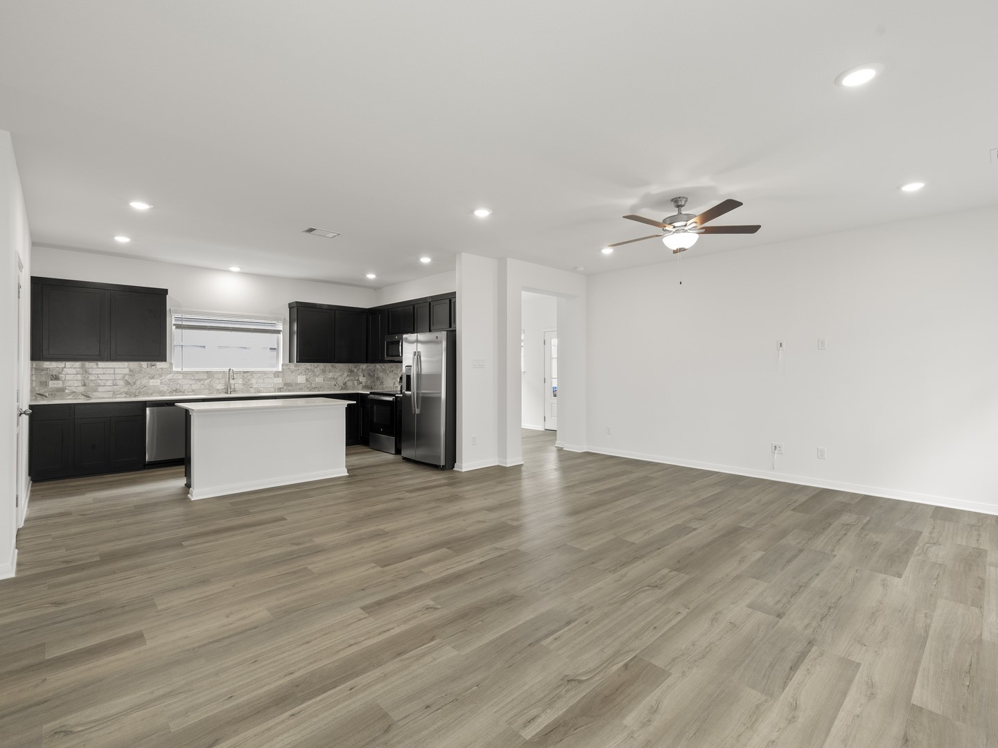 513 Yellow Ribbon Trail Jarrell, TX 76537 - Photo 6 of 23 An open concept design seamlessly connects a modern kitchen to a generous living area, ideal for entertaining.