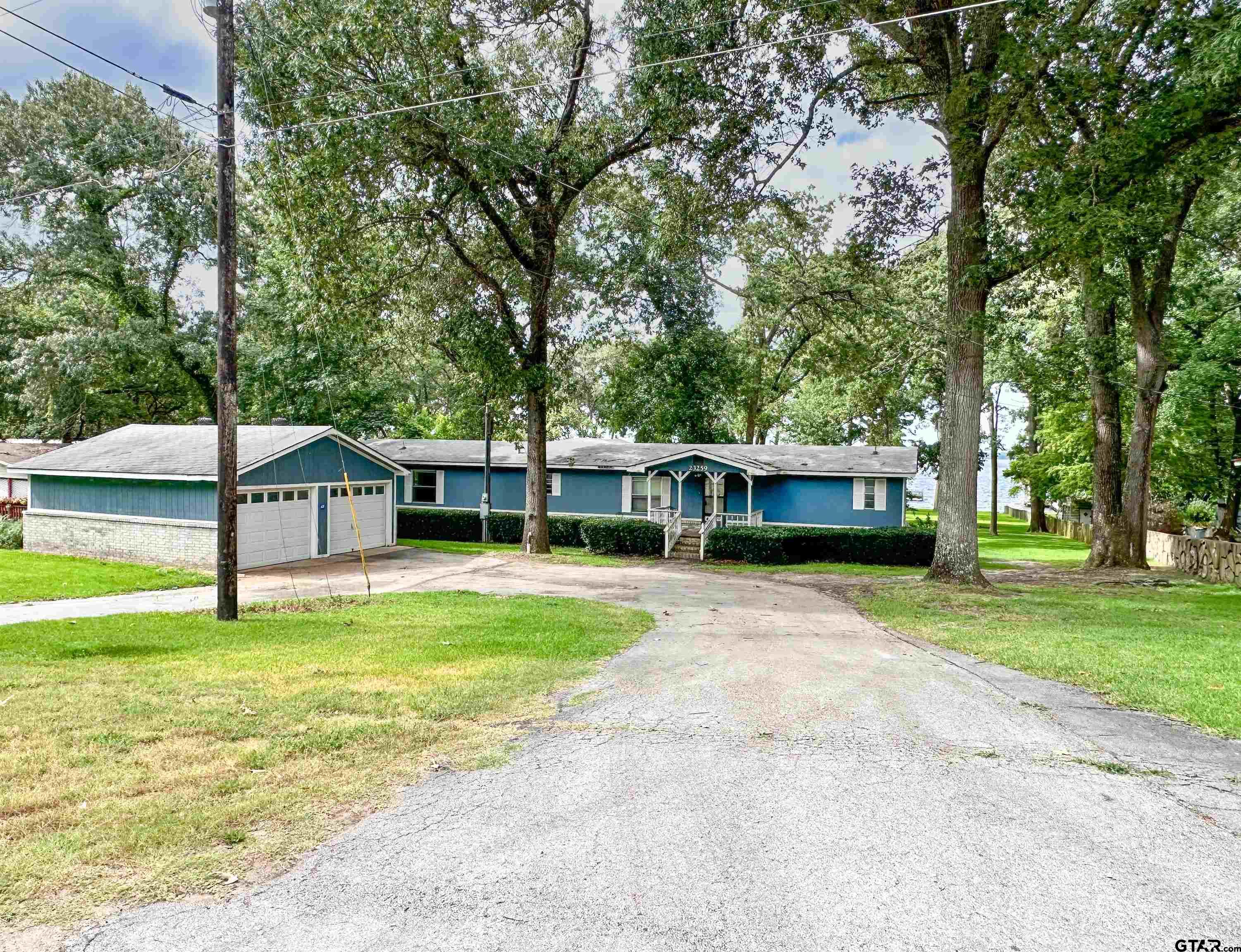 a front view of a house with a garden and trees