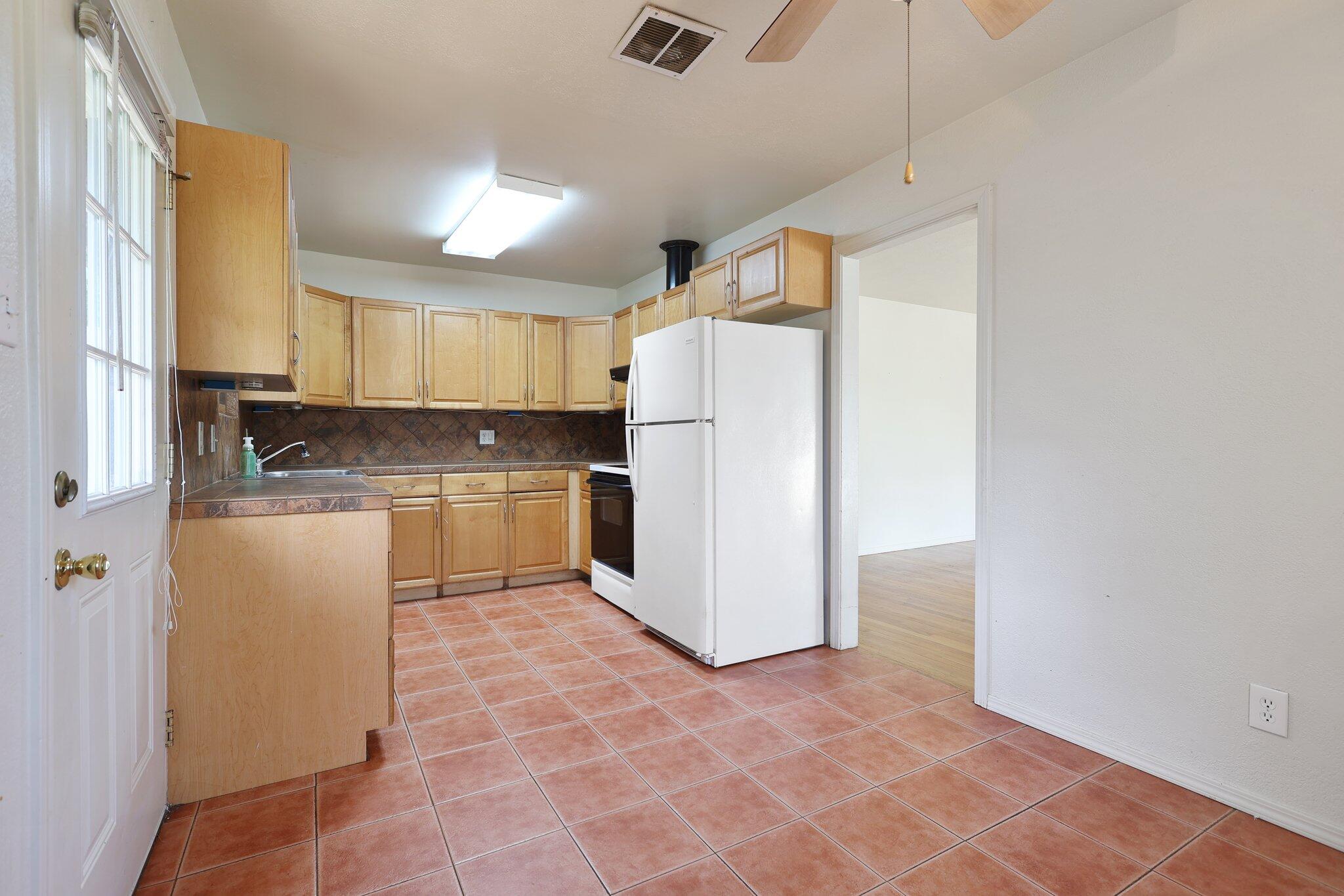 3581 Echo Road Redding, CA 96002 - Photo 4 of 19 a kitchen with a refrigerator a counter top space and cabinets
