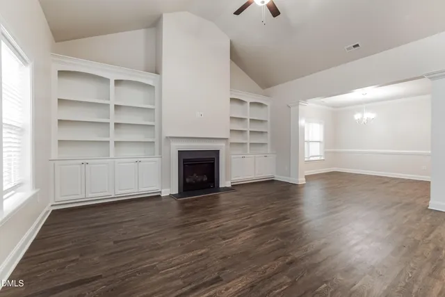 a view of an empty room with a window and fireplace