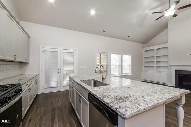 a kitchen with granite countertop sink stove and refrigerator