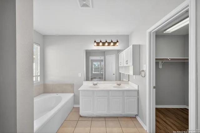 a bathroom with a sink a bathtub and a mirror