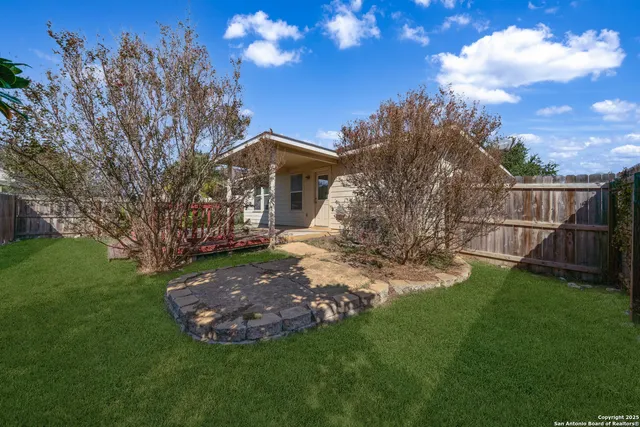 a view of a tree in front of a house with a yard
