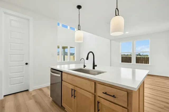 a kitchen with kitchen island a sink and wooden floor