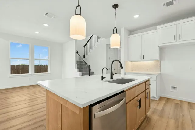 a kitchen with kitchen island a sink appliances and a large window