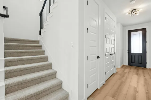 a view of a hallway with wooden floor and staircase