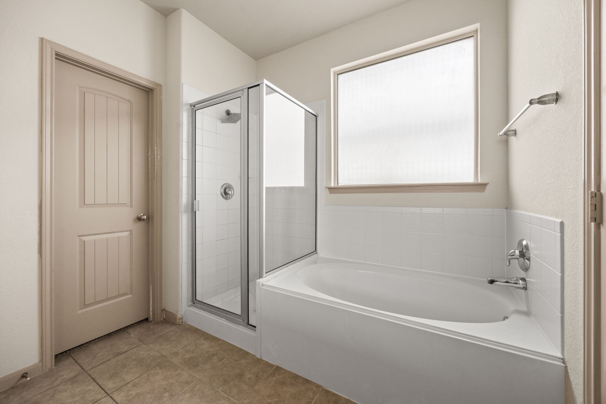 3606 Canvasback Lane Houston, TX 77047 - Photo 17 of 29 Relax in the spacious primary bath featuring a soaking tub, separate glass-enclosed shower, oversized frosted window for natural light, and a private linen closet.