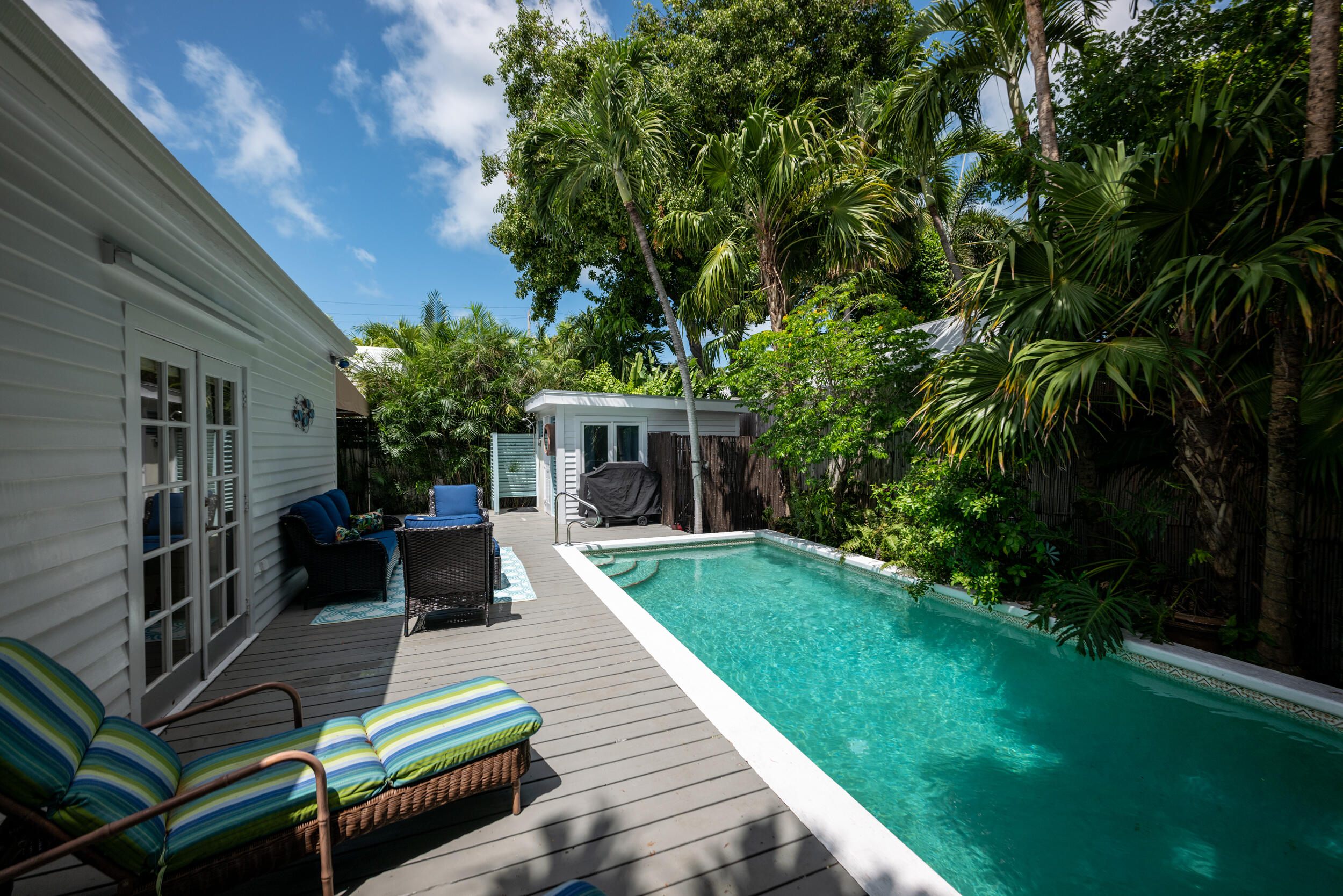 1109 Stump Lane Key West, FL 33040 - Photo 17 of 38 a view of a patio with table and chairs potted plants and large tree