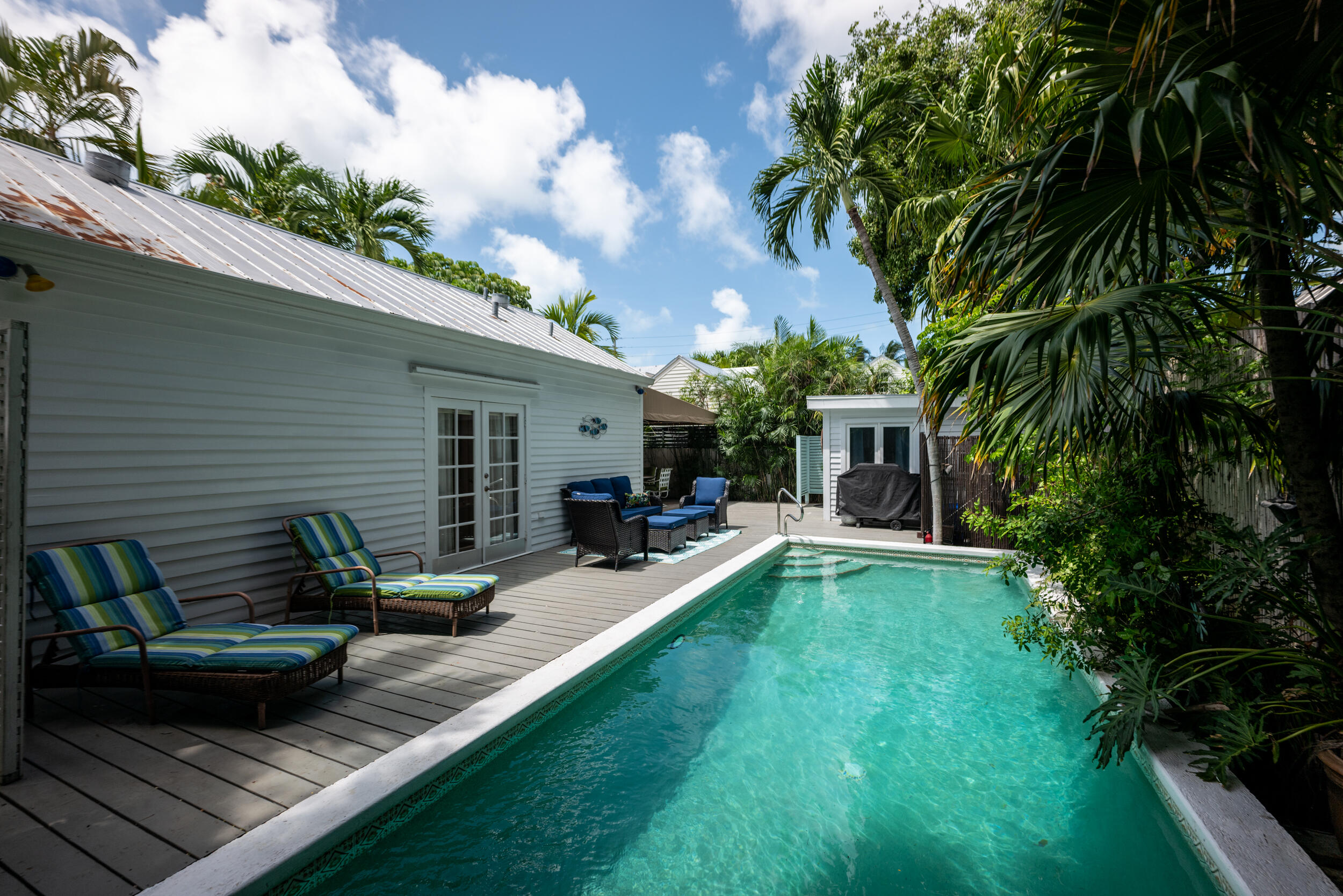 1109 Stump Lane Key West, FL 33040 - Photo 10 of 38 a view of a backyard with couches table and chairs and potted plants