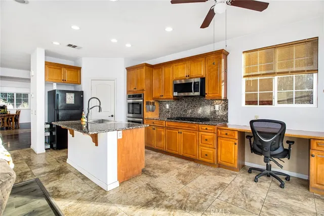 a kitchen with stainless steel appliances granite countertop sink stove top oven and cabinets