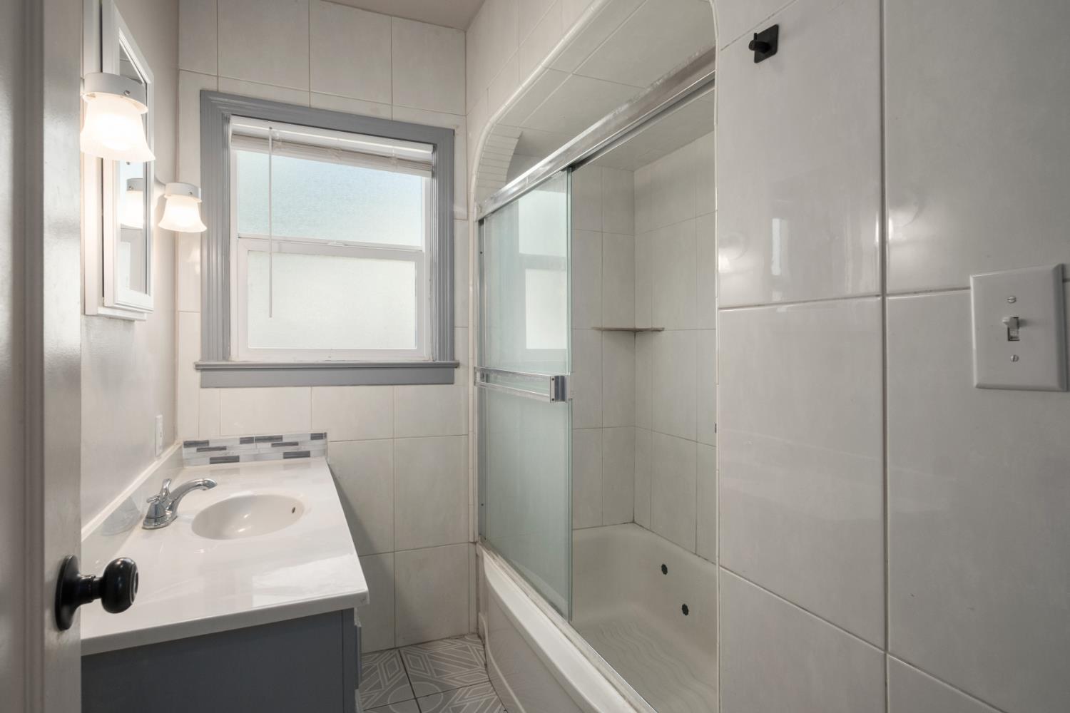 2043 11th Street Reedley, CA 93654 - Photo 11 of 21 a bathroom with a sink a bath tub and a shower