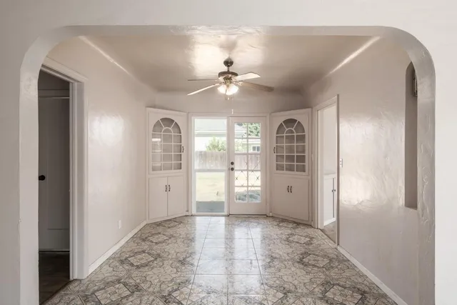 a view of a big room with windows and chandelier fan