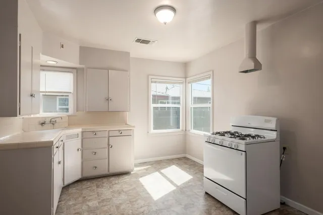 a kitchen that has a sink and a stove in it