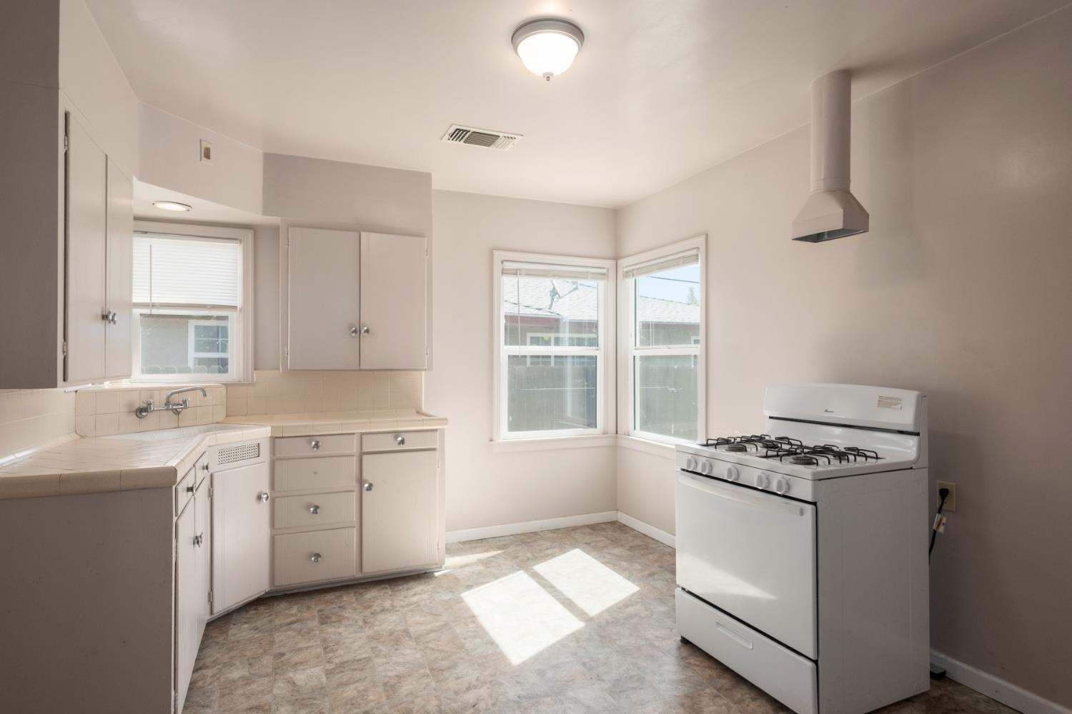 2043 11th Street Reedley, CA 93654 - Photo 7 of 21 a kitchen that has a sink and a stove in it