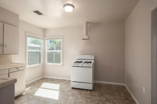 a kitchen with a stove a sink and a window