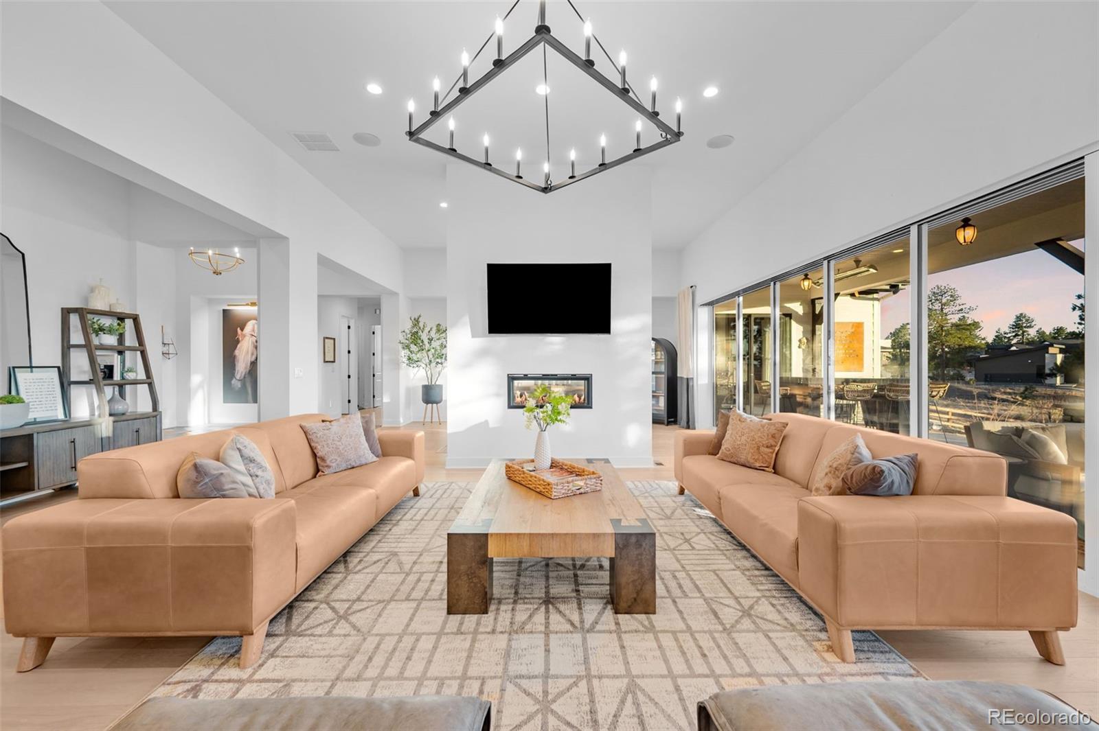 6001 Powell Road Parker, CO 80134 - Photo 11 of 50 a living room with furniture a chandelier and a flat screen tv