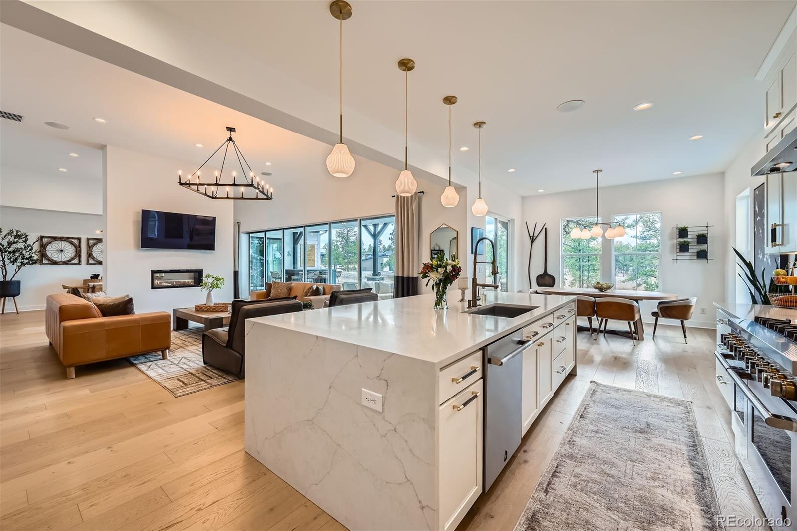 6001 Powell Road Parker, CO 80134 - Photo 19 of 50 a large kitchen with kitchen island a large counter top a sink a stove and a chandelier