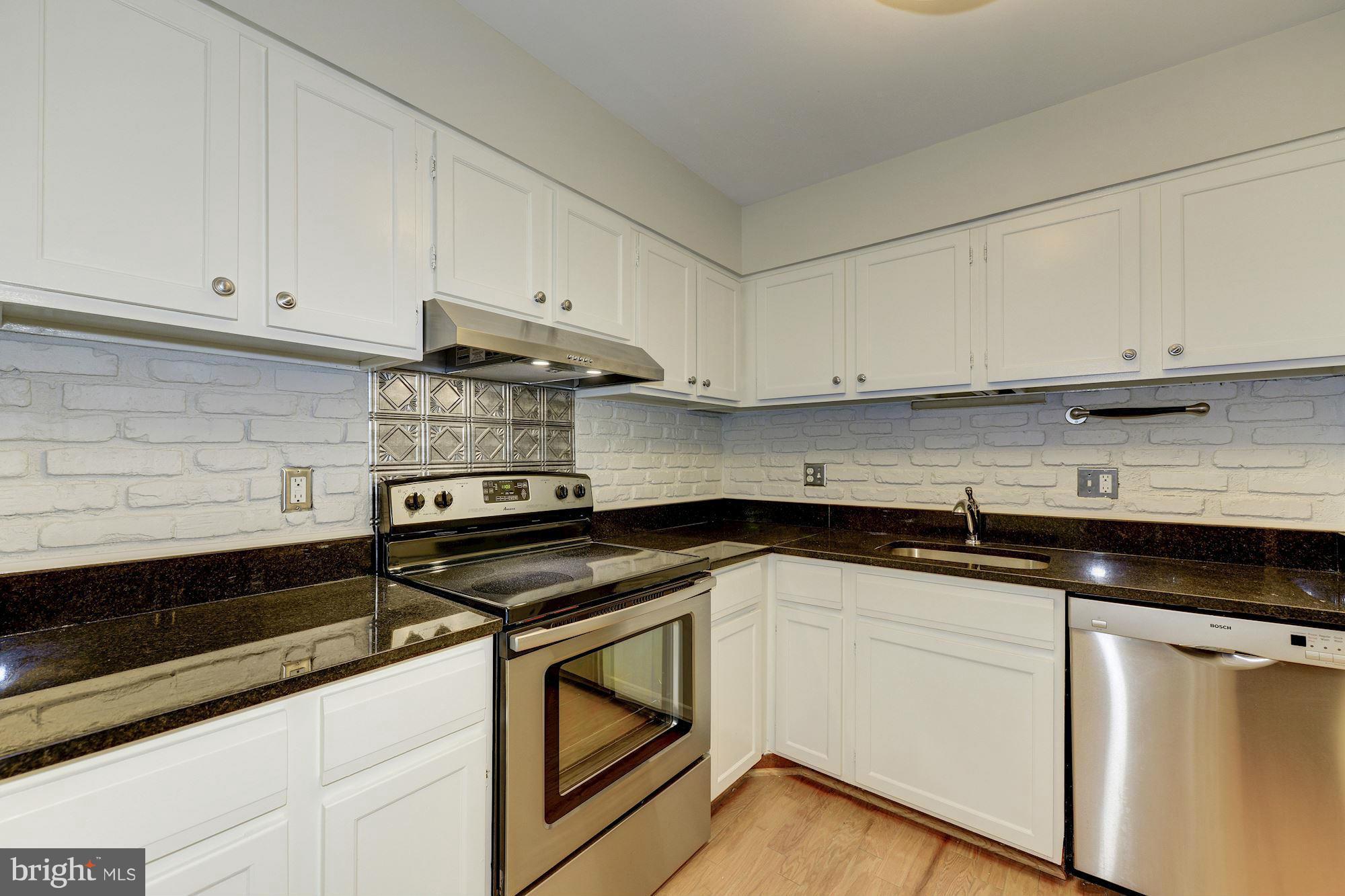 6155 Edsall Road, Unit H Alexandria, VA 22304 - Photo 13 of 30 a kitchen with granite countertop white cabinets and black appliances
