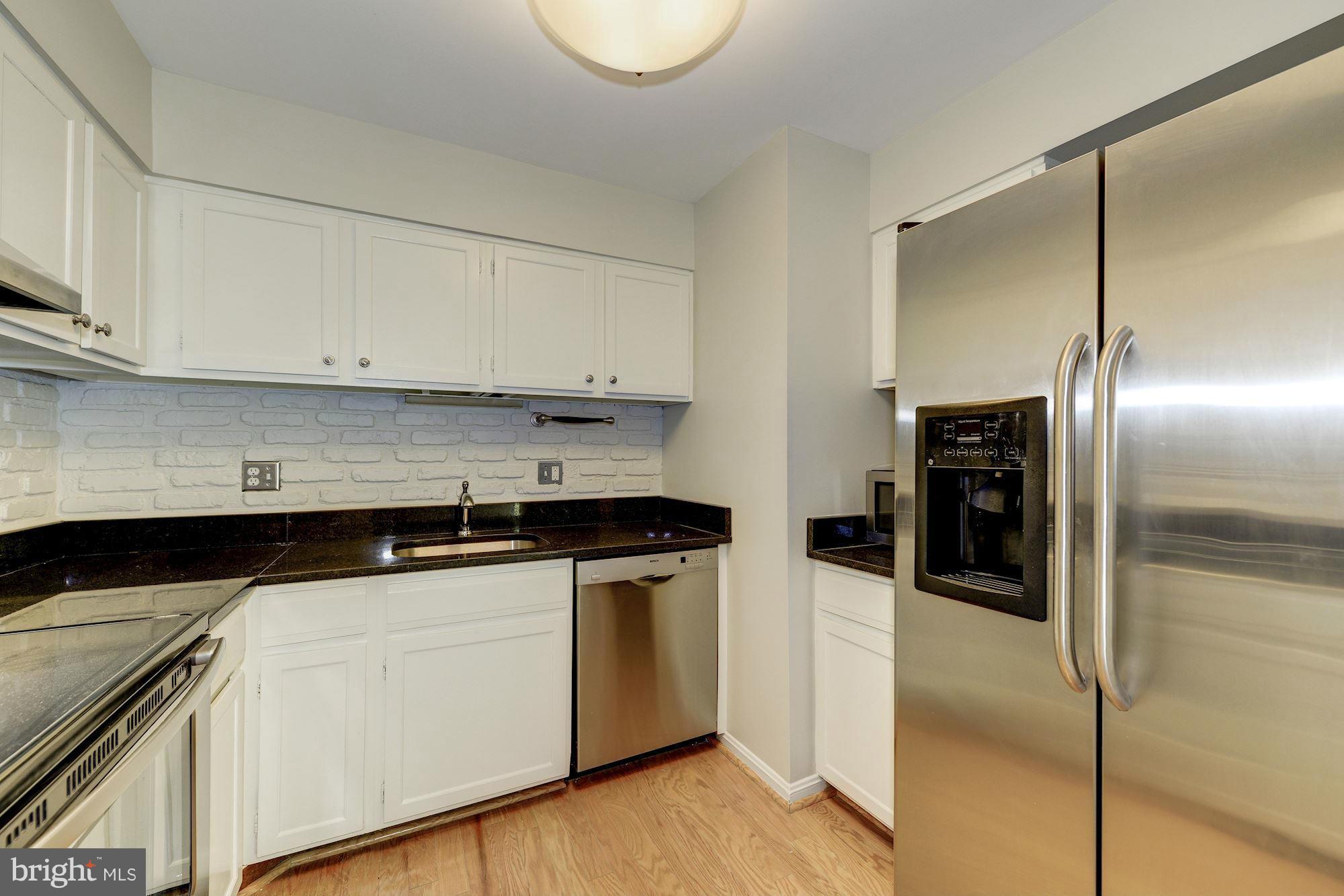 6155 Edsall Road, Unit H Alexandria, VA 22304 - Photo 14 of 30 a kitchen with stainless steel appliances granite countertop a refrigerator a stove and white cabinets