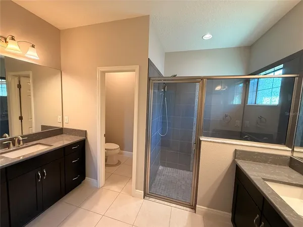 a bathroom with a double vanity sink toilet and shower