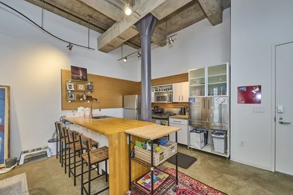 a kitchen with stainless steel appliances kitchen island granite countertop a table and chairs