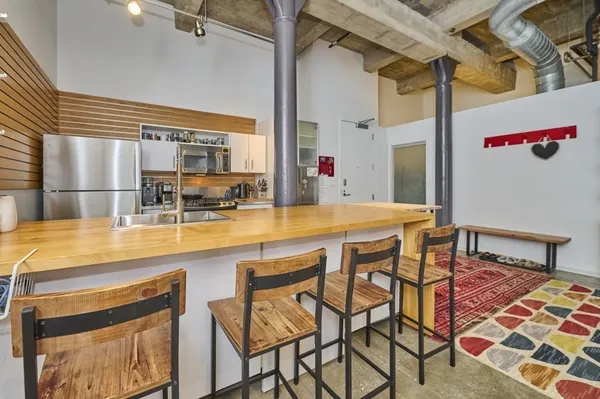 a kitchen with a sink and chairs