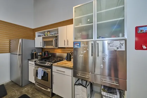 a kitchen with stainless steel appliances granite countertop a refrigerator a stove and a sink