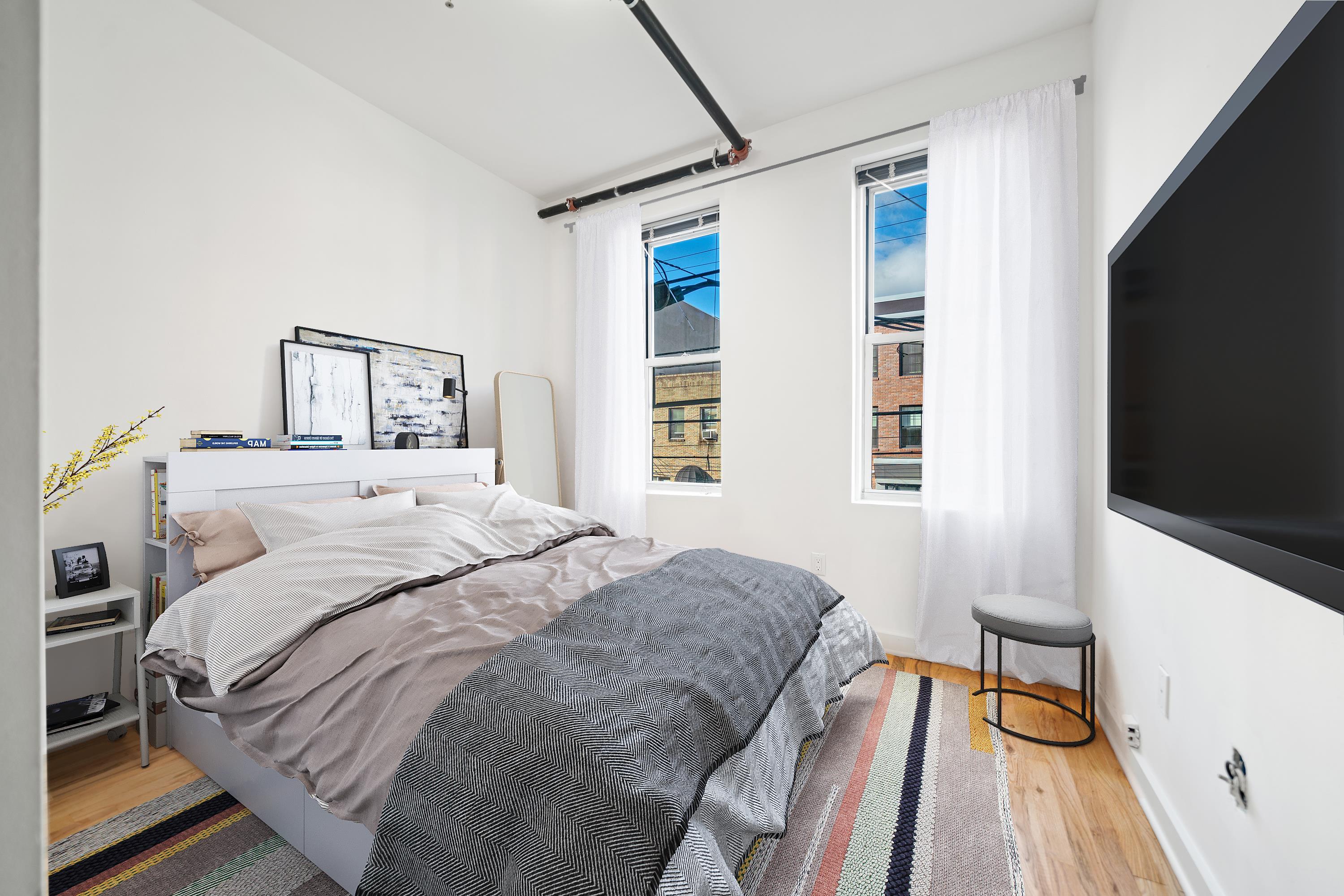615 Monroe Street, Unit 1 Hoboken, NJ 07030 - Photo 4 of 10 a bedroom with a bed and a flat tv screen on a dresser