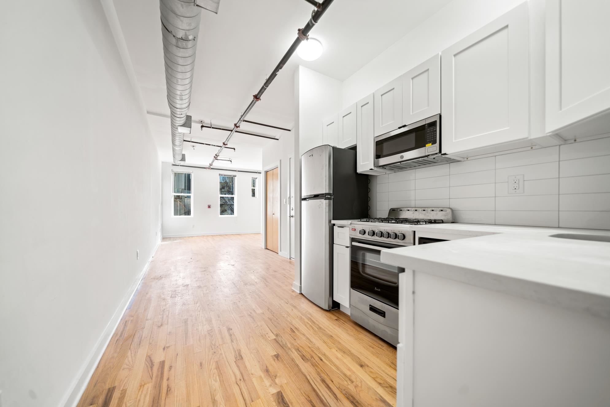 615 Monroe Street, Unit 1 Hoboken, NJ 07030 - Photo 9 of 10 a kitchen with stainless steel appliances a white refrigerator a stove top oven a sink and dishwasher